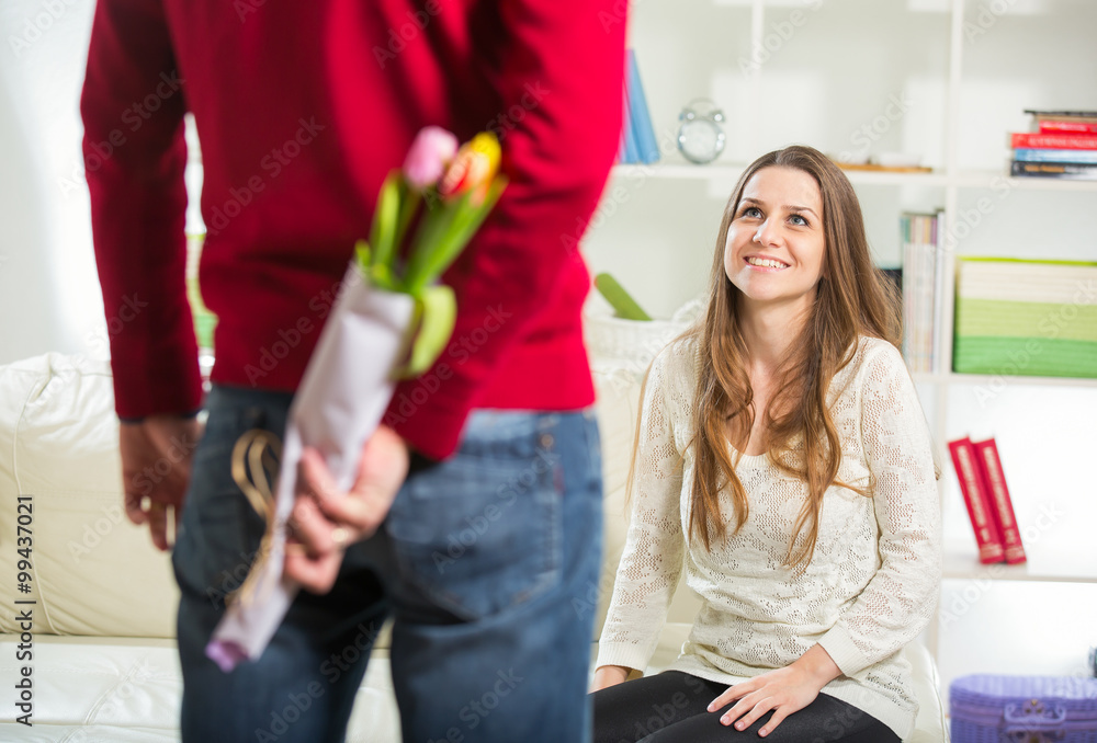 Young guy brings flowers to his girlfriend. Selective focus Young guy brings flowers to his girlfriend. Selective focus