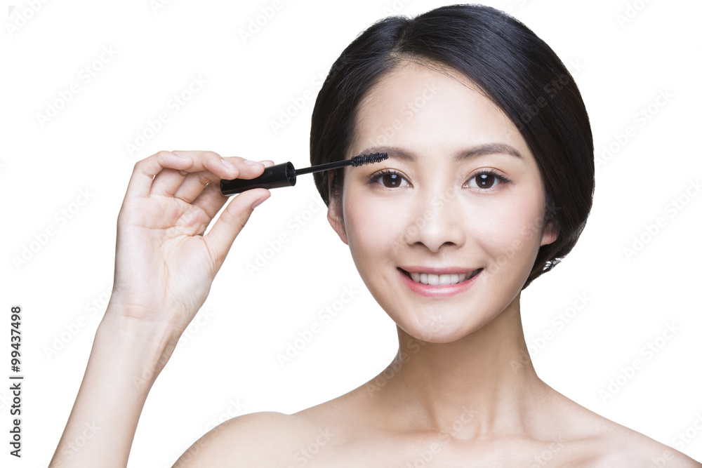 Beautiful young woman applying mascara Beautiful young woman applying mascara