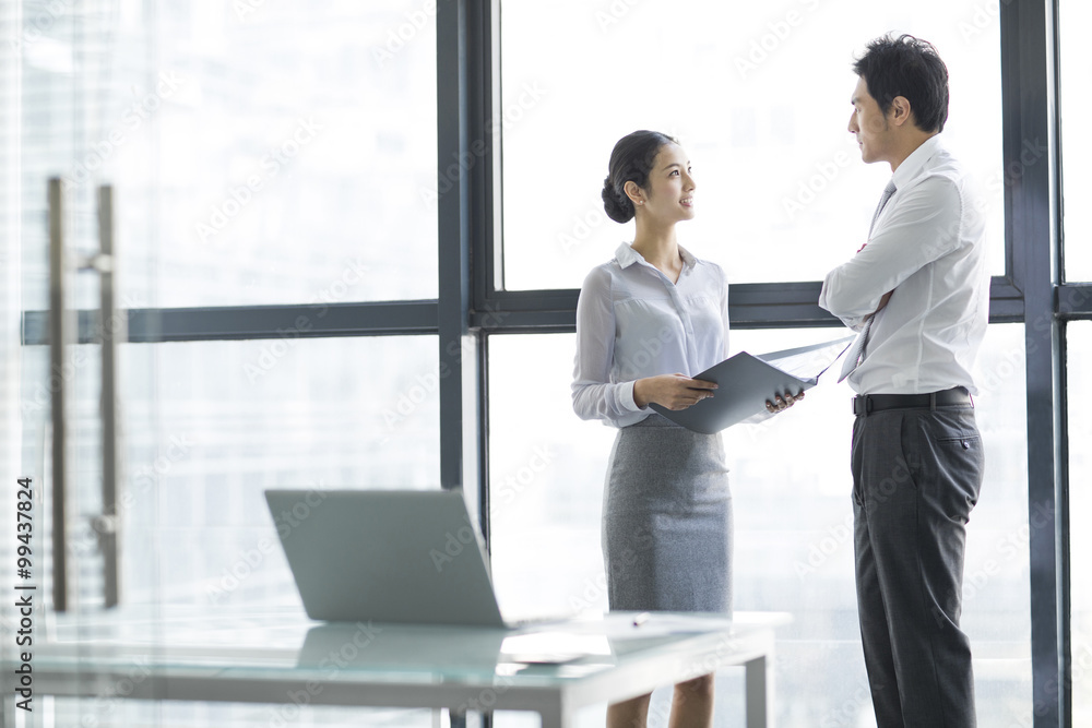 Young businesswoman and businessman talking in office Young businesswoman and businessman talking in office