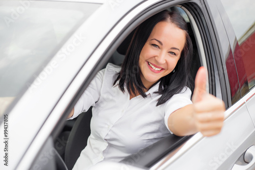 Wallpaper Mural Woman showing thumbs up while driving her new car  Torontodigital.ca