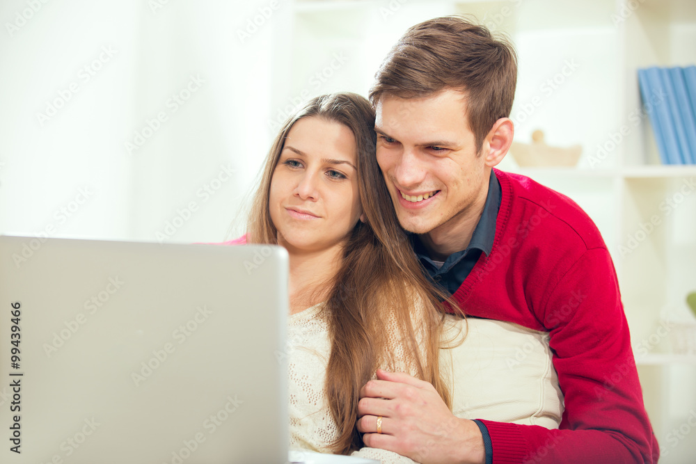 Young couple relaxing on sofa with laptop in the living room.Selective focus Young couple relaxing on sofa with laptop in the living room.Selective focus