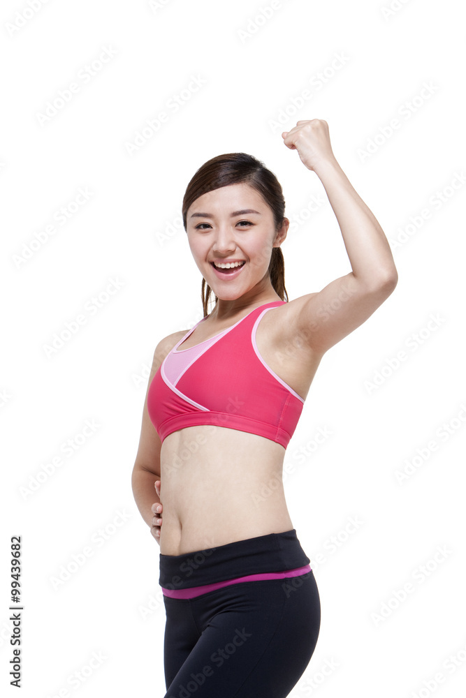 Young woman in sports clothing flexing her muscles Young woman in sports clothing flexing her muscles