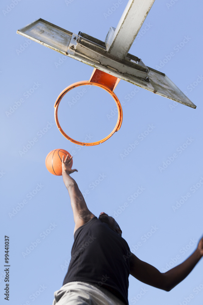 Fototapeta premium Basketball player jumping to dunk