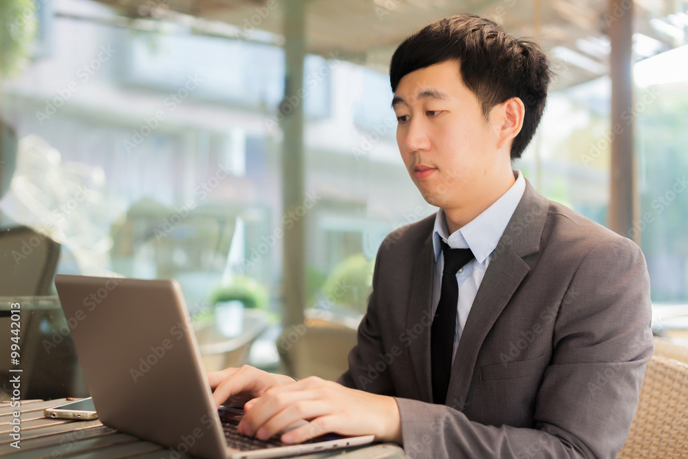 Young Asian businessman working with his laptop in outdoor scene Young Asian businessman working with his laptop in outdoor scene