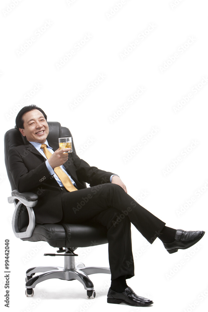 Senior businessman enjoying whiskey on director's chair Senior businessman enjoying whiskey on director's chair