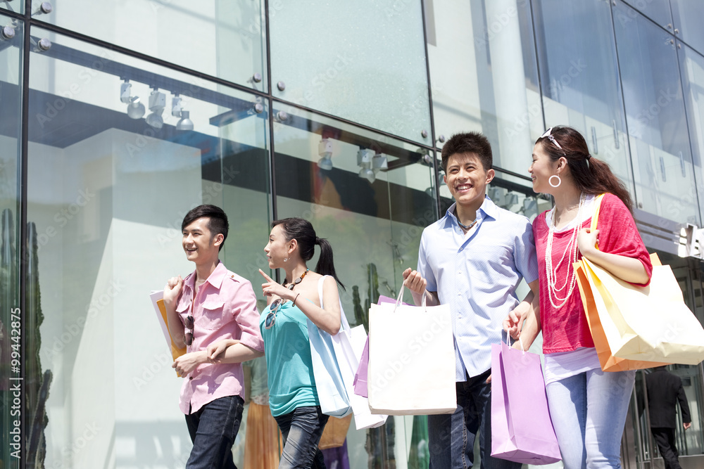 Four friends holding shopping bags Four friends holding shopping bags