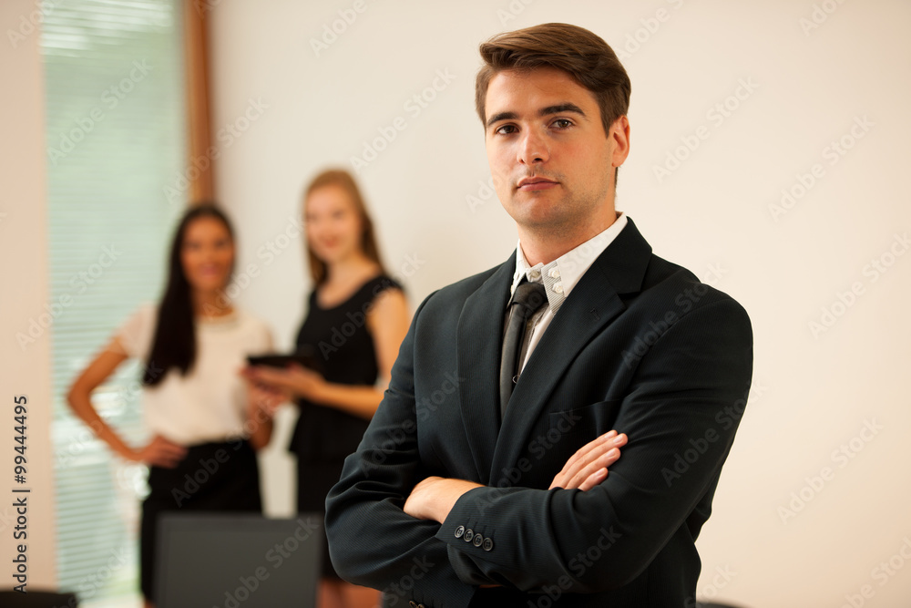 Young Business man standing in first plain with coworkers in b Young Business man standing in first plain with coworkers in b