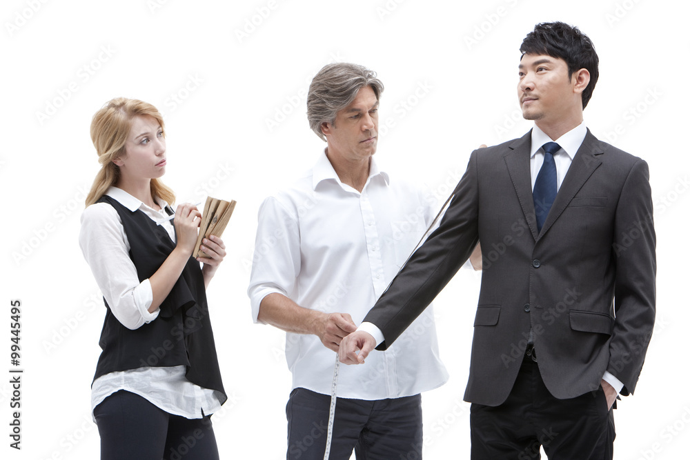 Fototapeta premium Fashion designer taking a measurement of businessman
