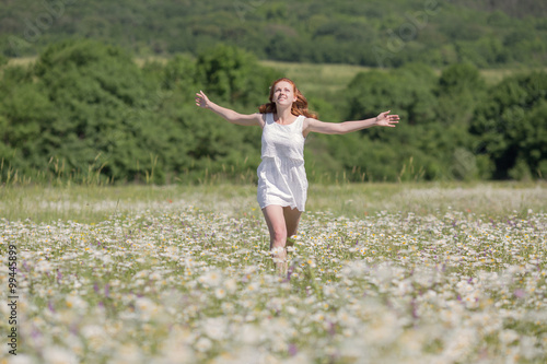 Ginger girl runs on meadow