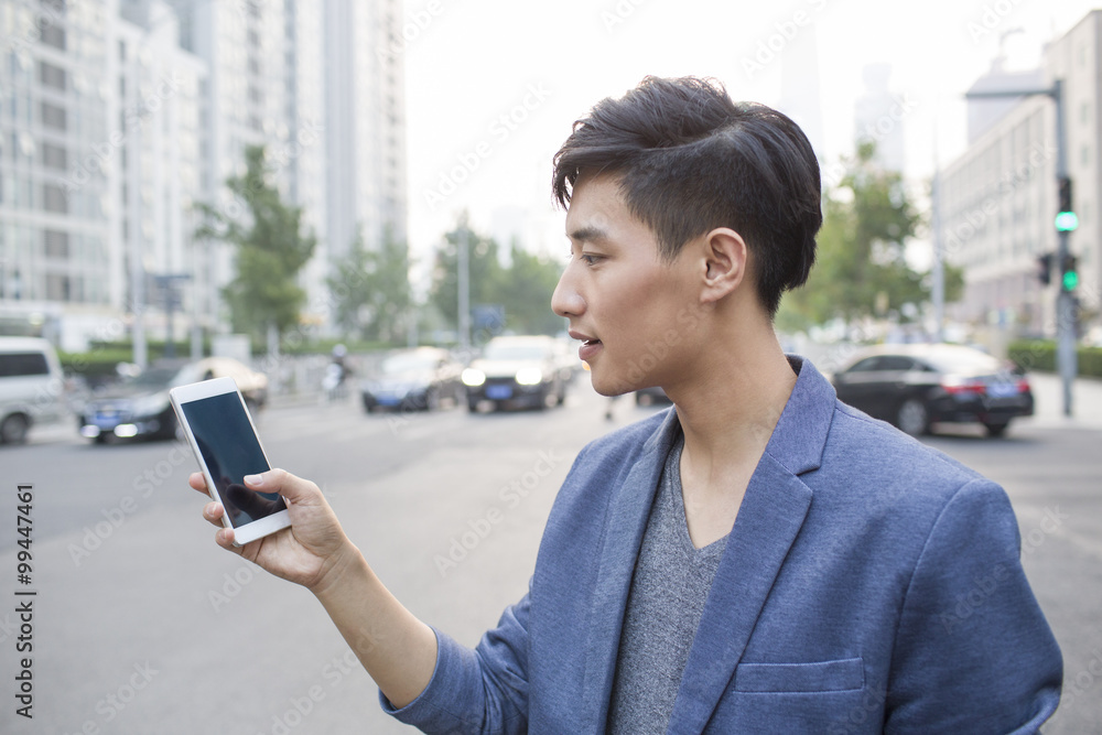 Young man waiting for taxi with smart phone Young man waiting for taxi with smart phone