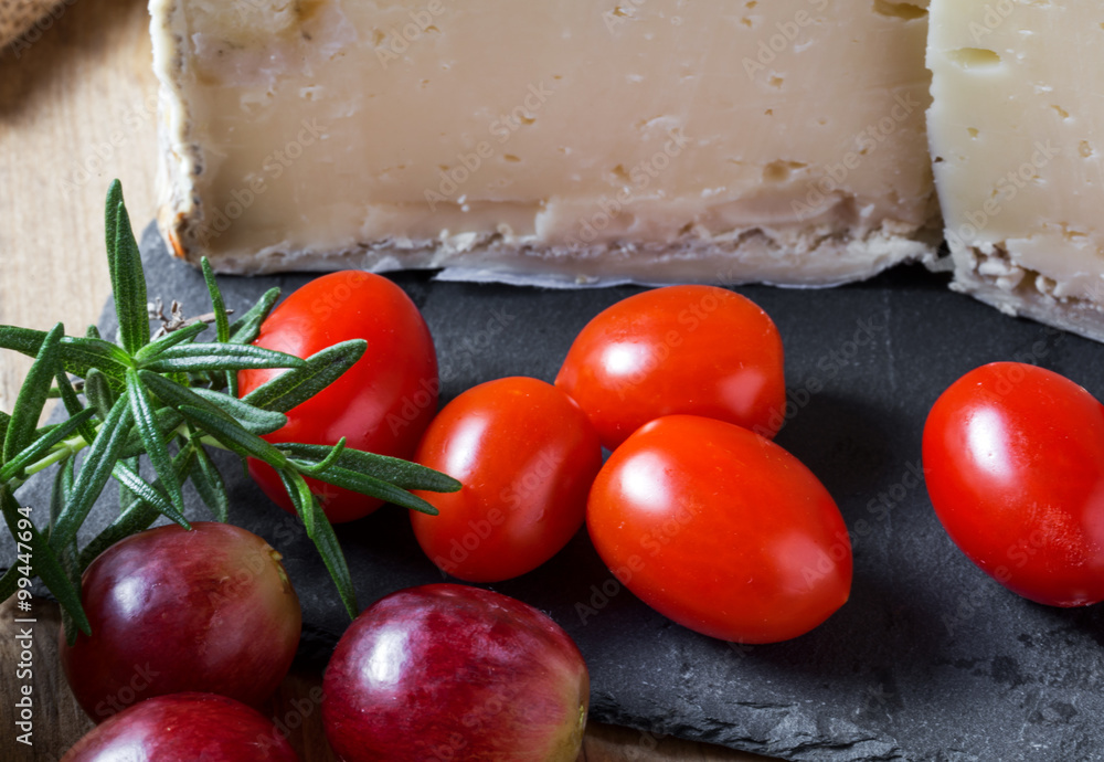 Typical Spanish cheese with wine, grapes and cherry tomatoes Typical Spanish cheese with wine, grapes and cherry tomatoes