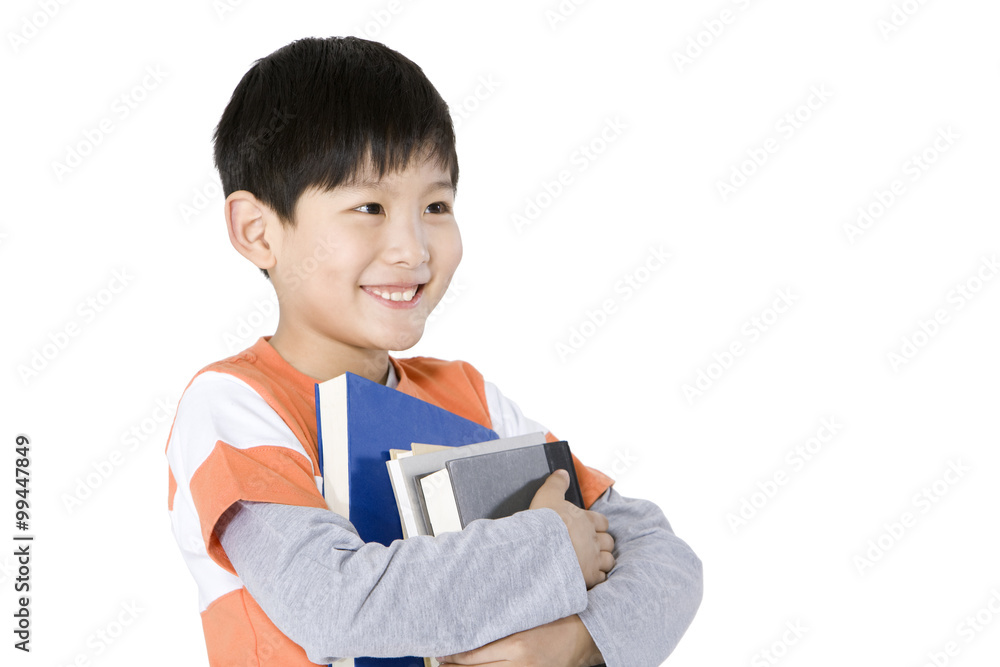 Happy young boy carrying a stack of books Happy young boy carrying a stack of books