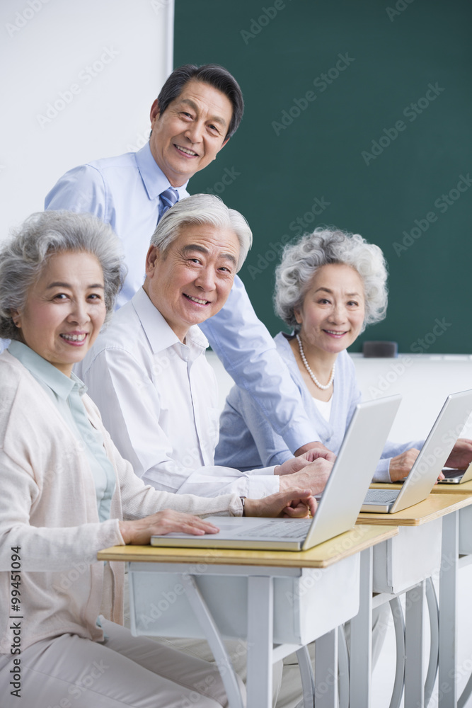 Fototapeta premium Senior adults having computer class at school