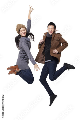 Stylish young people jumping in mid-air