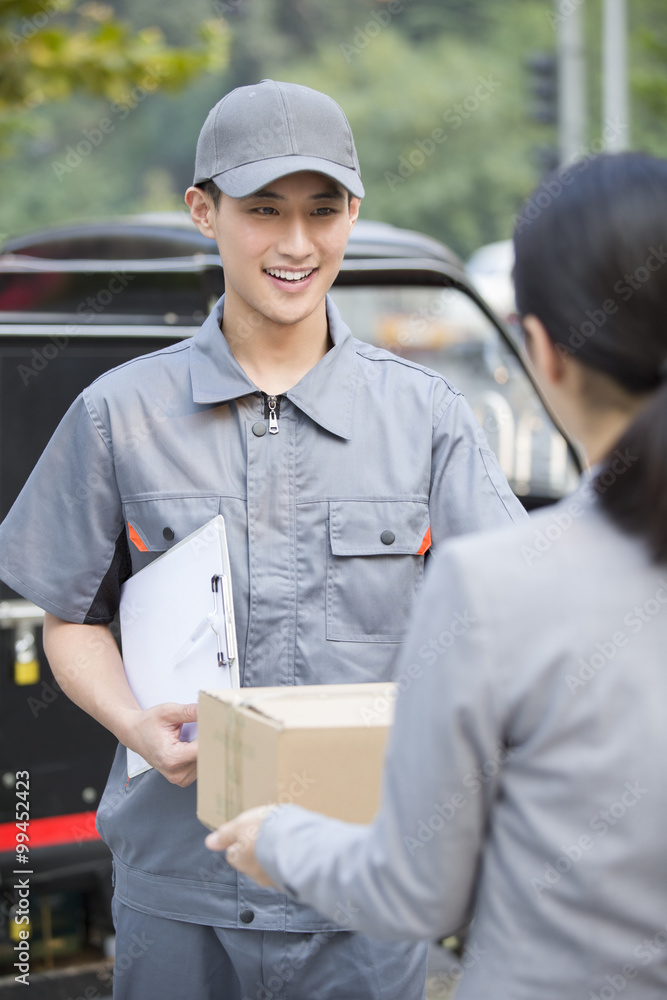Young woman getting a package from delivery person Young woman getting a package from delivery person