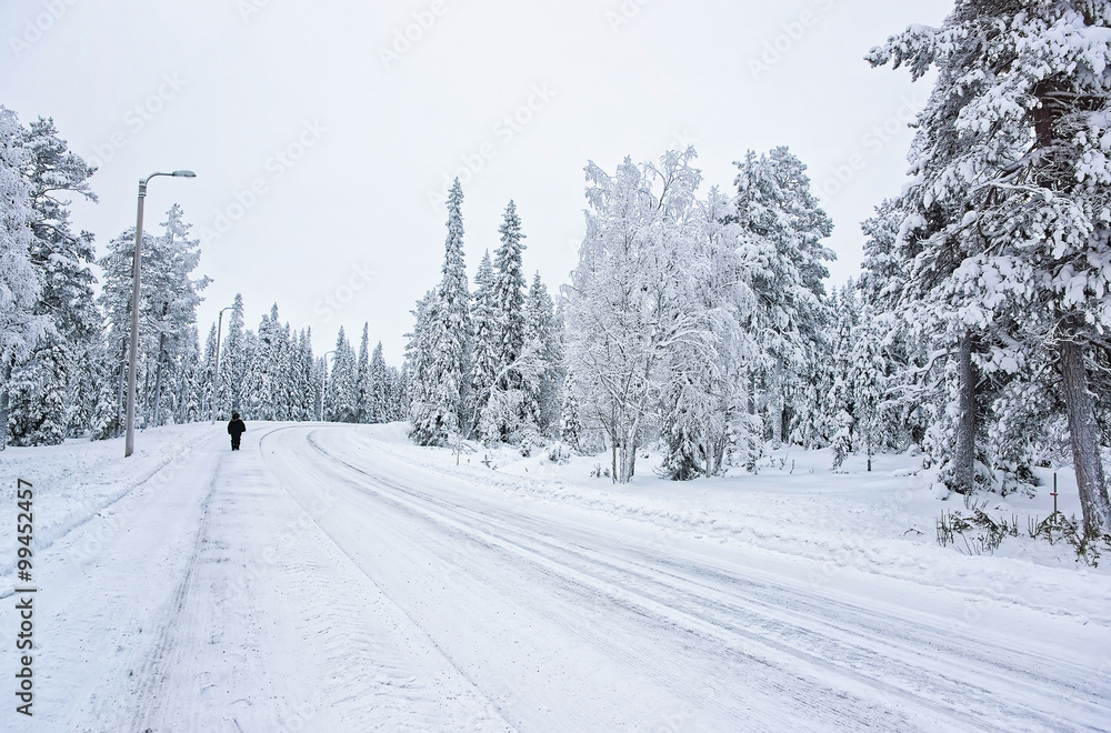 Man in the snow covered road in Ruka in Finland in the Arctic circle