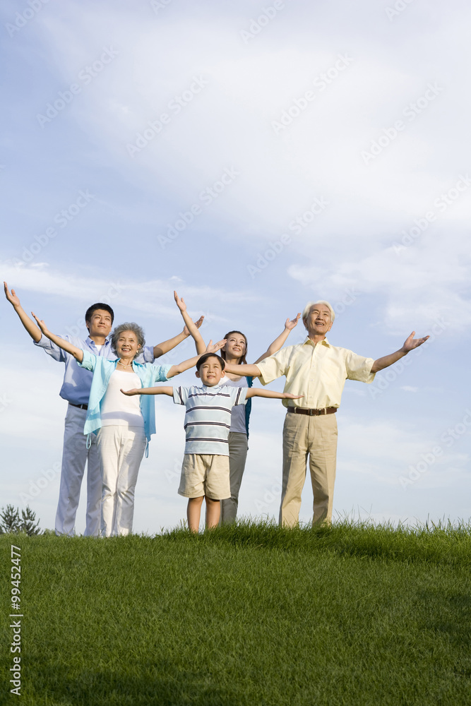 Family standing on the grass, arms outstretched Family standing on the grass, arms outstretched