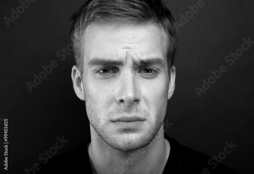 Black and white portrait photo of young man with sad look in v n