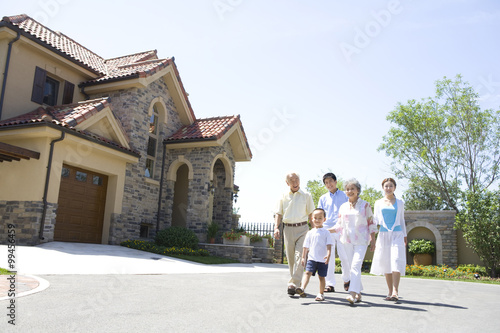 Three generation family walking by a house