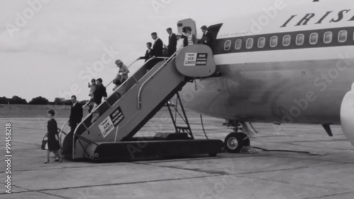 Wide shot of passengers disembarking airplane photo