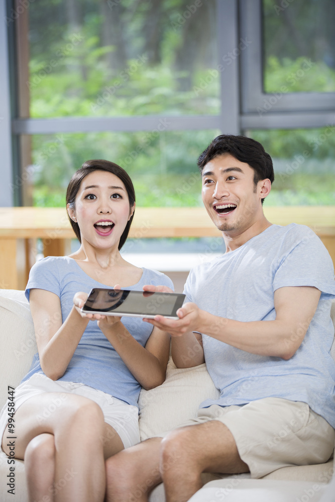 Young couple cheering with digital tablet Young couple cheering with digital tablet