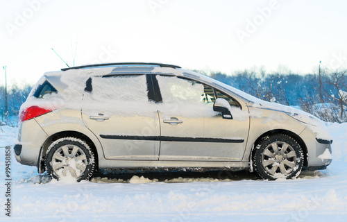 Car covered with snow in the winter. © M-Production