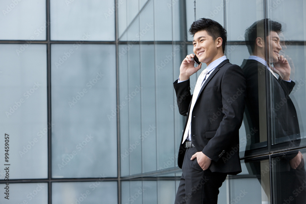 Businessman on the phone leaning against the wall Businessman on the phone leaning against the wall