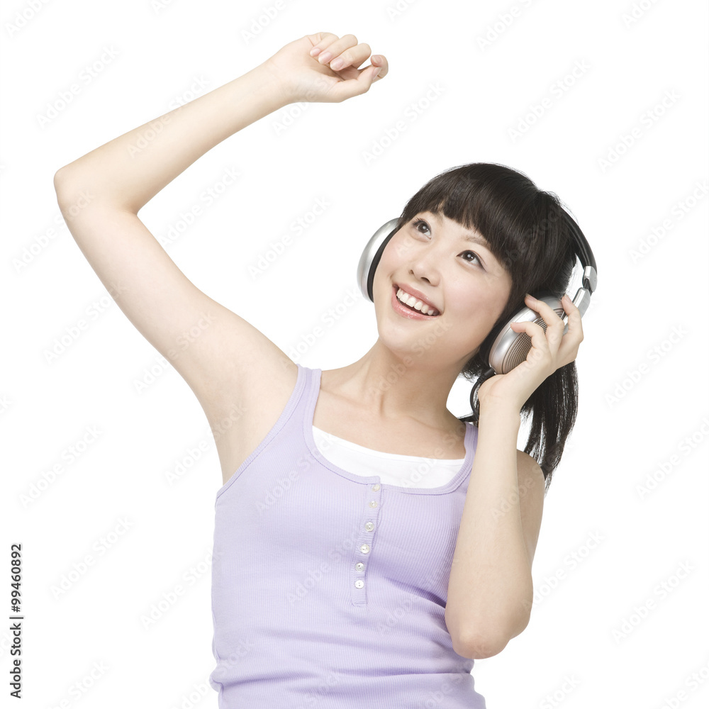 Naklejka premium Smiling young woman listening to music on headphones