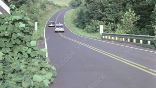 Rear view of police car chase on country road photo