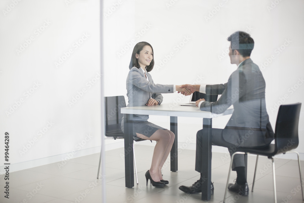 Business person shaking hands in meeting room Business person shaking hands in meeting room