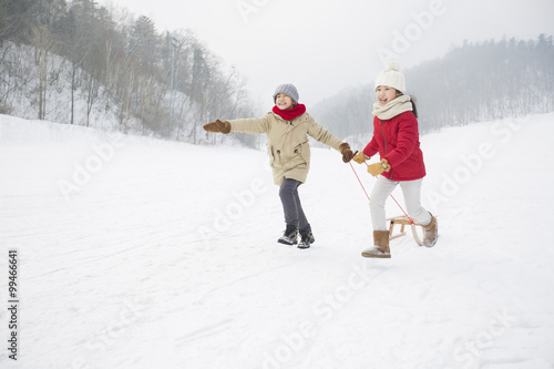 Behang Happy children running with sled on the snow