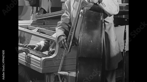 Medium shot of pianist accompanying bass player in band, 1950s