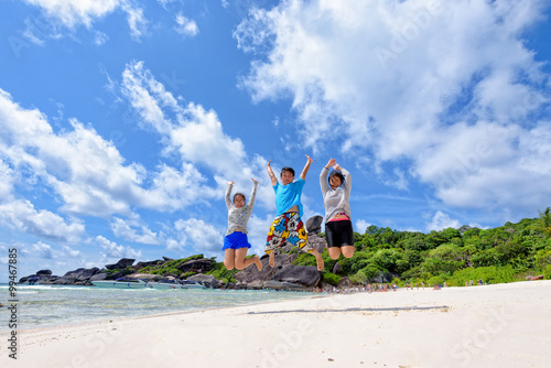 Family travels on vacation jumping with happy on beach near the sea under blue sky and clouds of summer at Koh Similan Island in Mu Ko Similan National Park, Phang Nga province, Thailand
