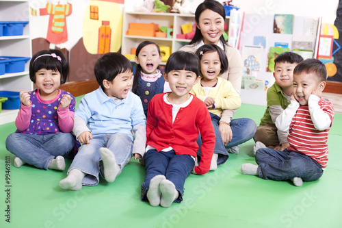 Female teacher with cute kindergarten children