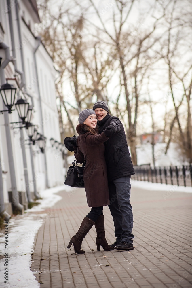 Portrait of happy young couple looking at camera in winter street. Natural emotions.
