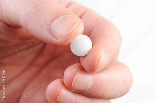 macro of white pill in hand photo