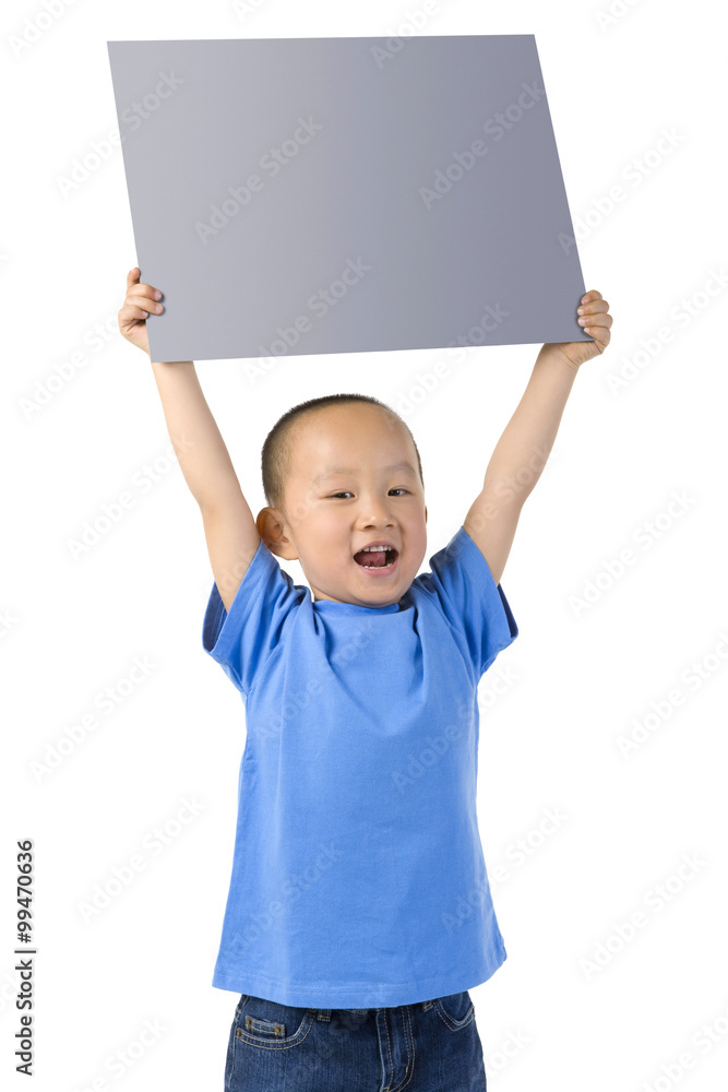 Young boy stands, holding a placard above his head Young boy stands, holding a placard above his head