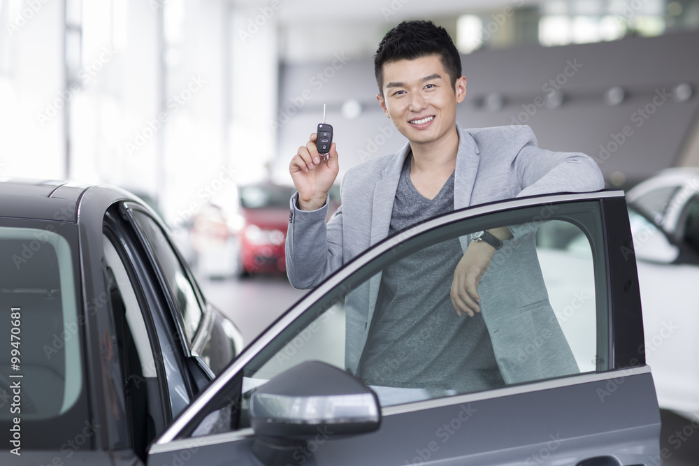 Young man buying car in showroom Young man buying car in showroom