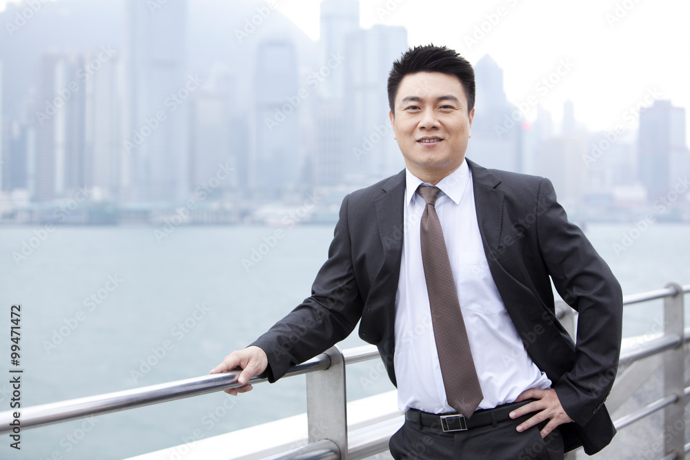 Adroit businessman hand on hip, Hong Kong Adroit businessman hand on hip, Hong Kong