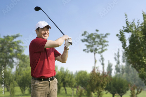 Male golfer swinging club