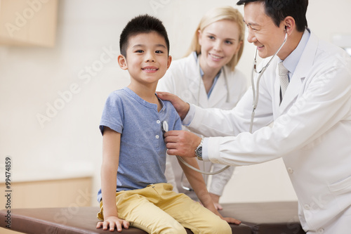 Doctor examining little boy with stethoscope