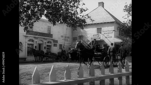 Wide shot of horse and buggy riding through town photo