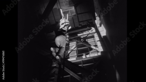 Two men climbing up shaky ladder photo