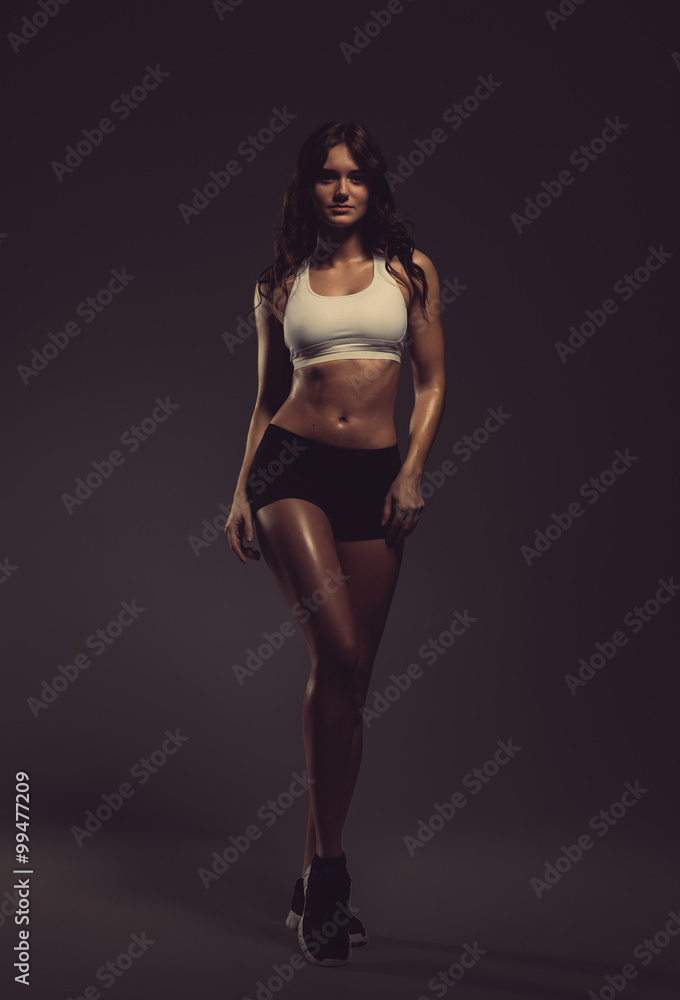 Beautiful young athletic woman posing in a studio