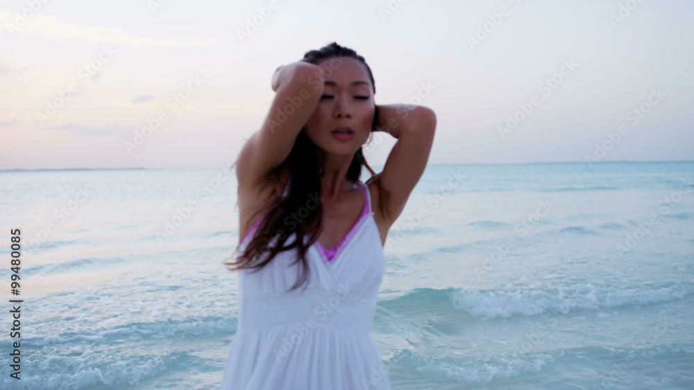 Beautiful Asian Chinese female dancing on tropical beach Beautiful Asian Chinese female dancing on tropical beach
