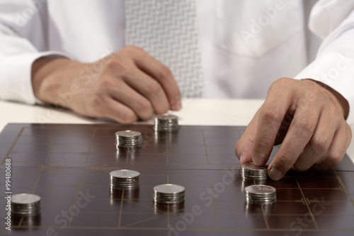 Office worker playing Chinese chess with investment capital