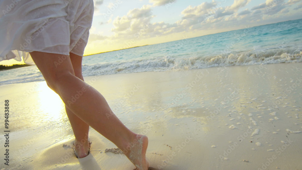 Legs of a barefoot Caucasian female enjoying island sunset Legs of a barefoot Caucasian female enjoying island sunset