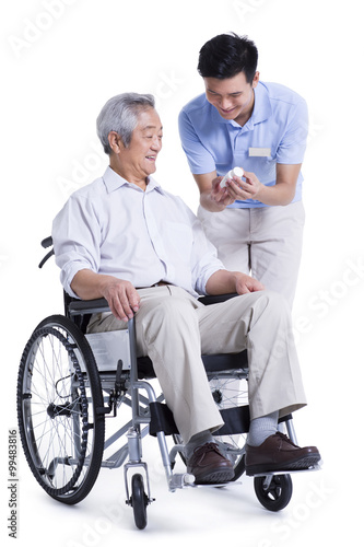 Male nursing worker showing senior man medicine