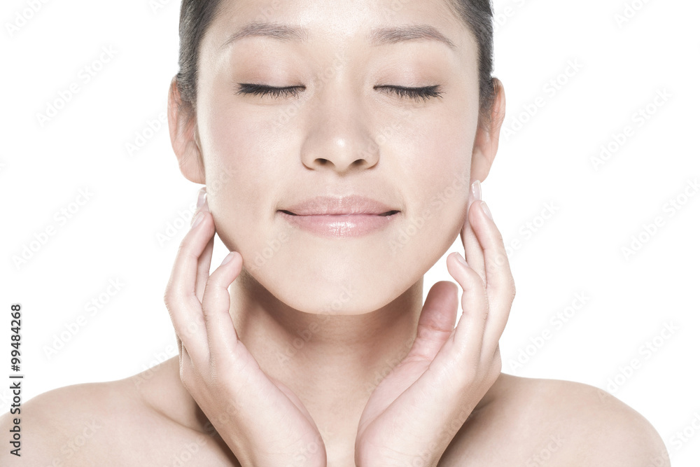 Beauty shot of a young woman touching her face