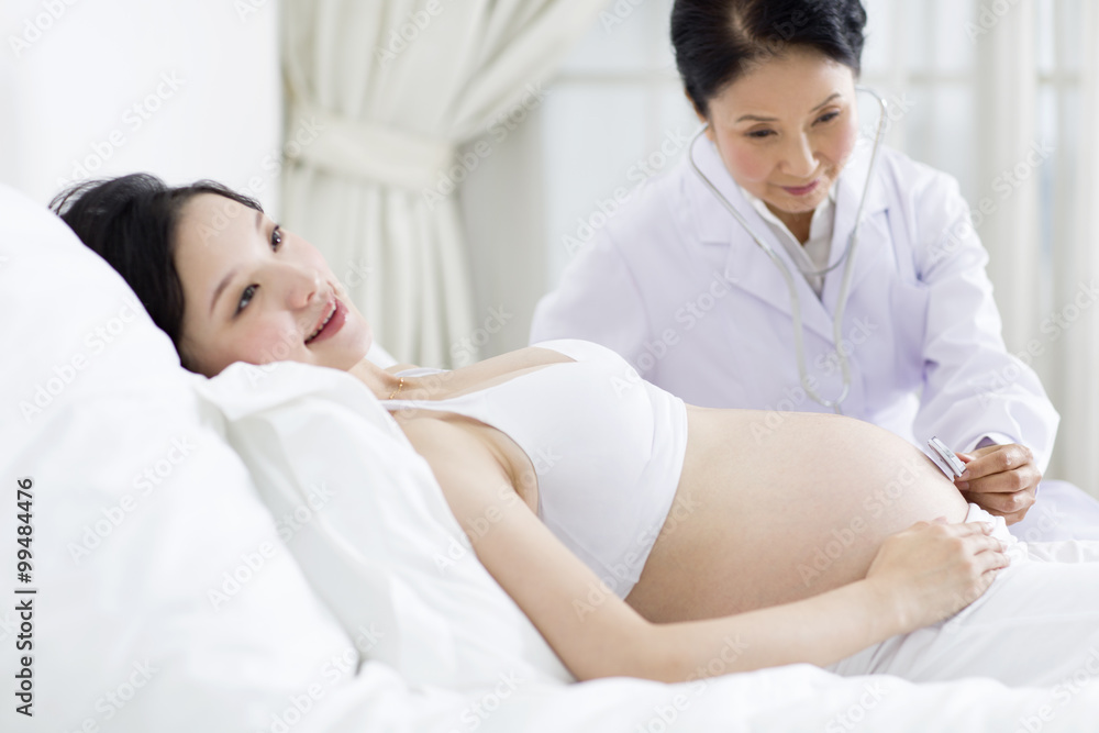 Doctor examining pregnant woman at home Doctor examining pregnant woman at home
